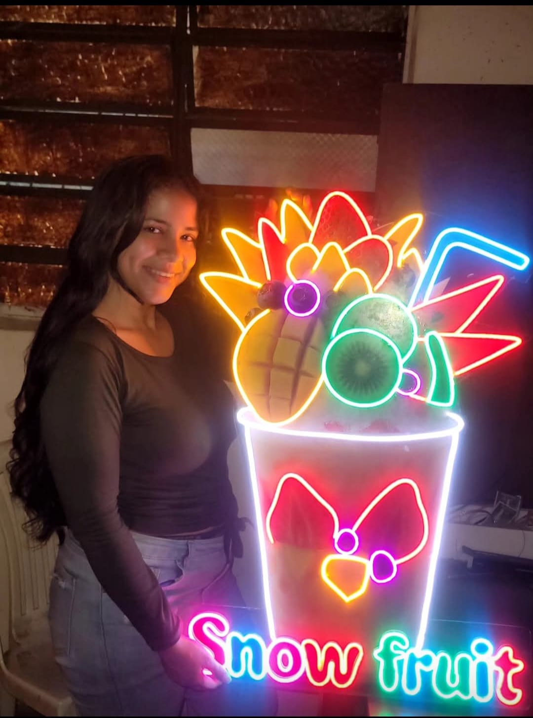 Fundador sosteniendo un letrero de neón personalizado